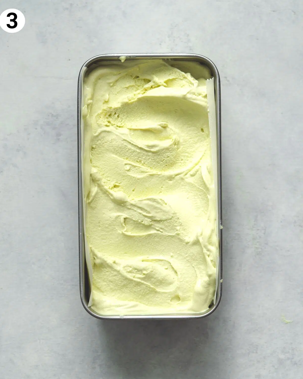 vegan pistachio ice cream in a metal tub.