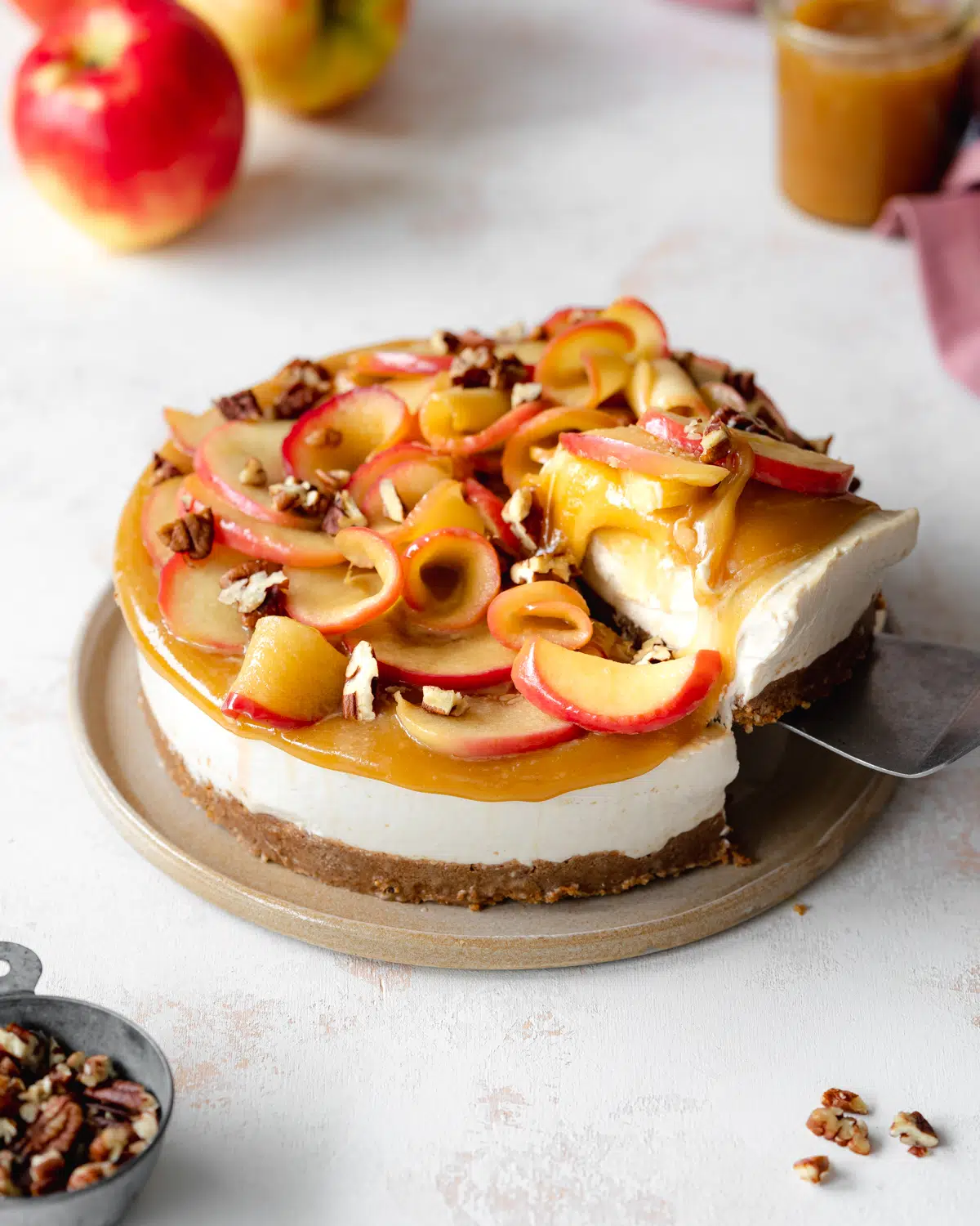 vegan cheesecake with caramel and apples on top.