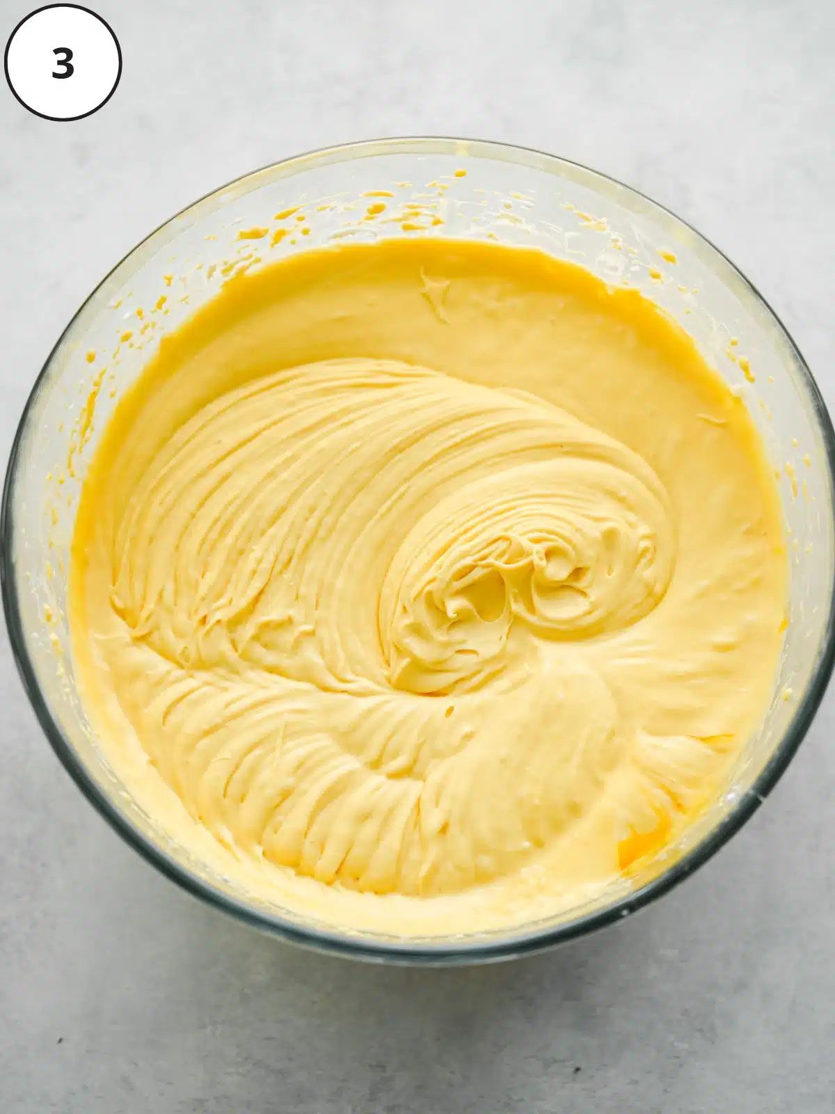 3 ingredient mango ice cream whisked in a bowl, it has a really thick and creamy consistency.