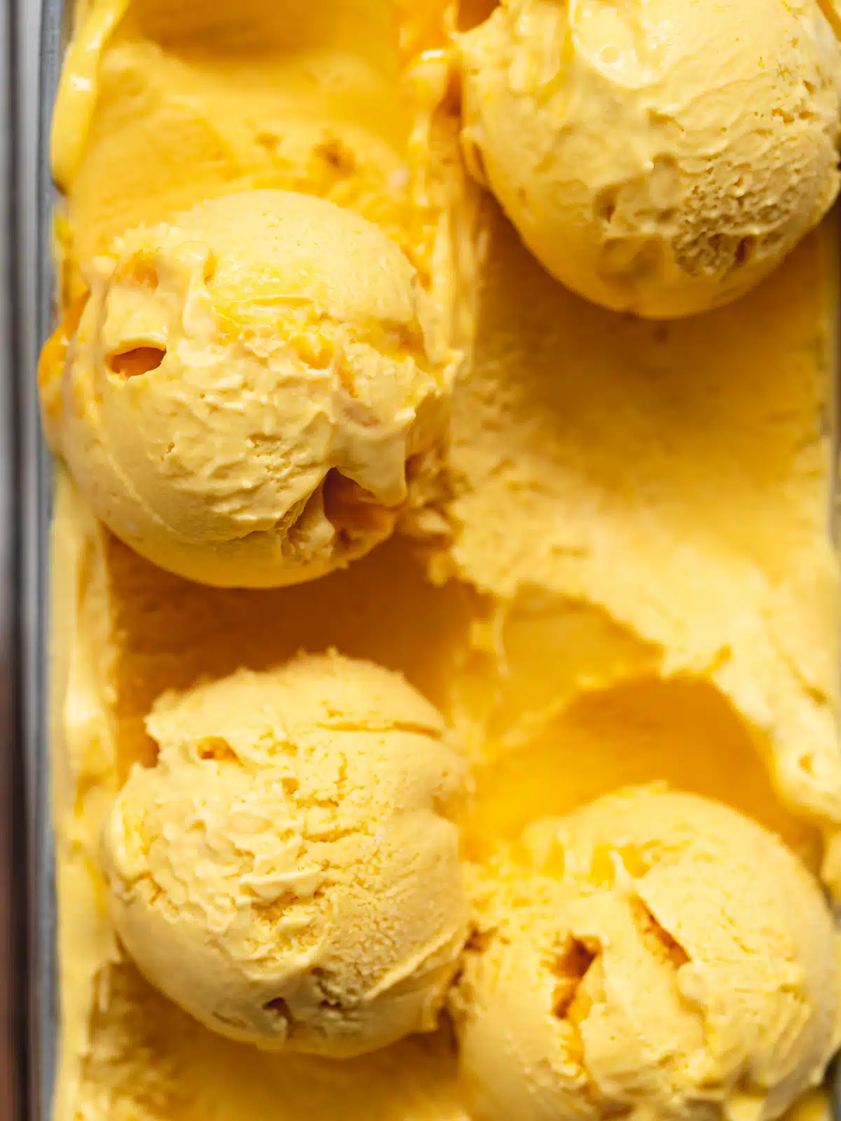 close up of mango ice cream scoops showing the incredible thick and creamy texture.