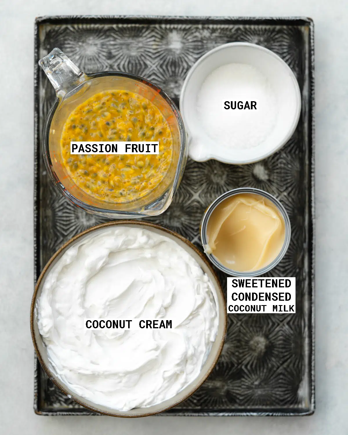 top down view of measured out ingredients for making passion fruit ice cream on a metal tray.