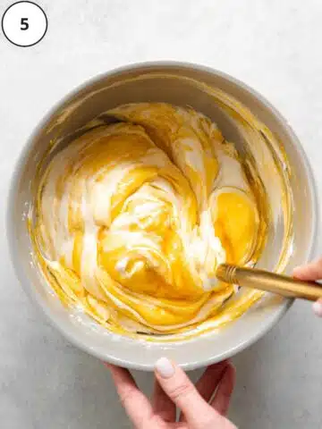 folding passion fruit puree through dairy-free ice cream with a spatula.