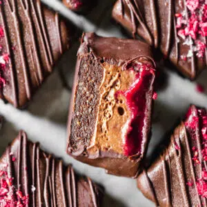 close up of brownie bars filled with chocolate mousse and raspberry sauce.