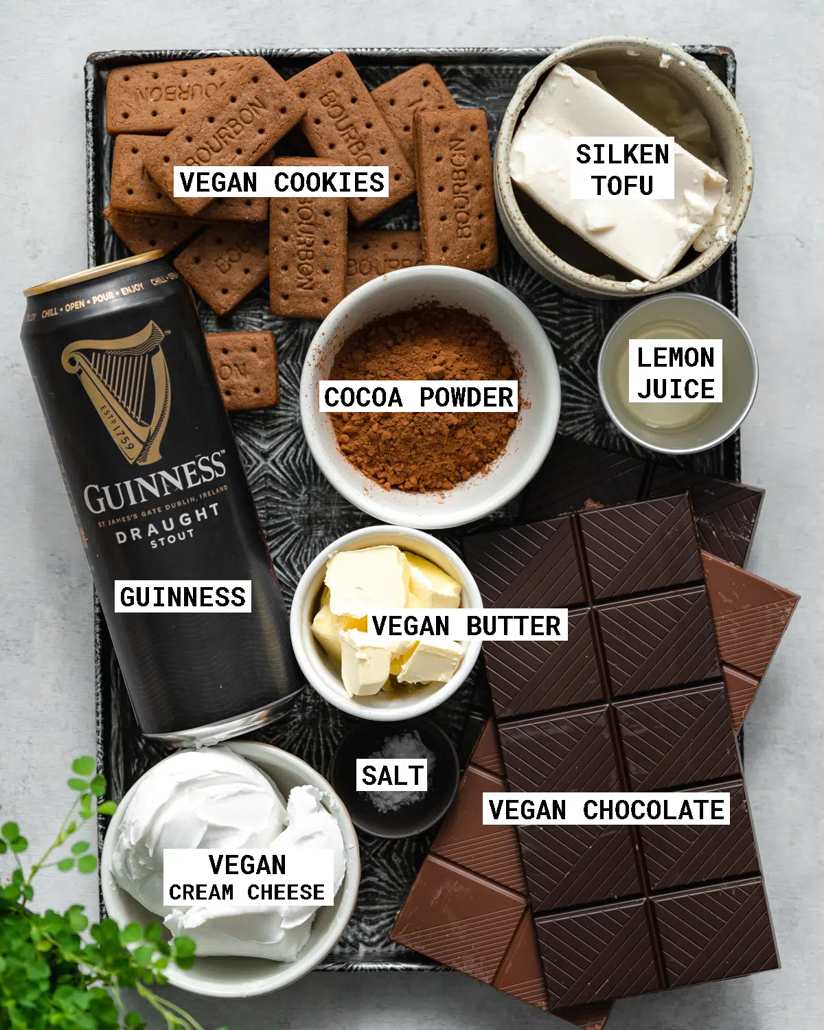 top down view of ingredients for guinness chocolate cheesecake laid out on a vintage metal tray.