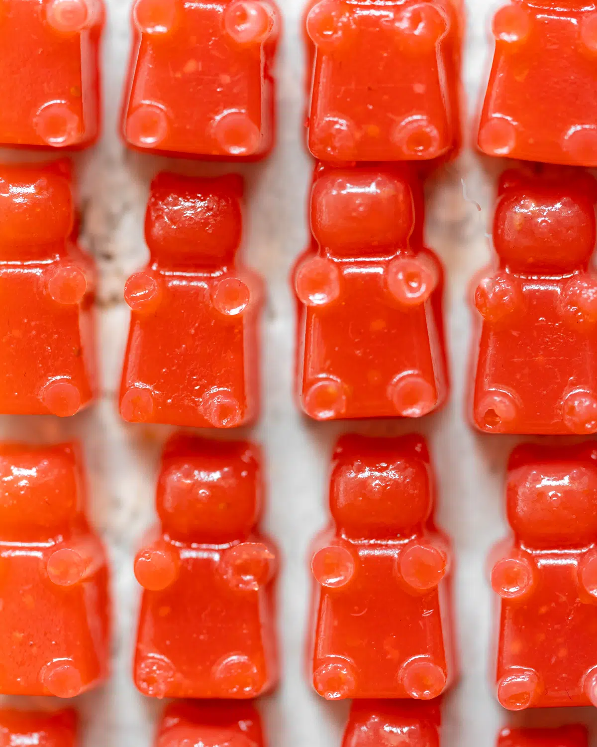 strawberry gummy bears on a white surface.