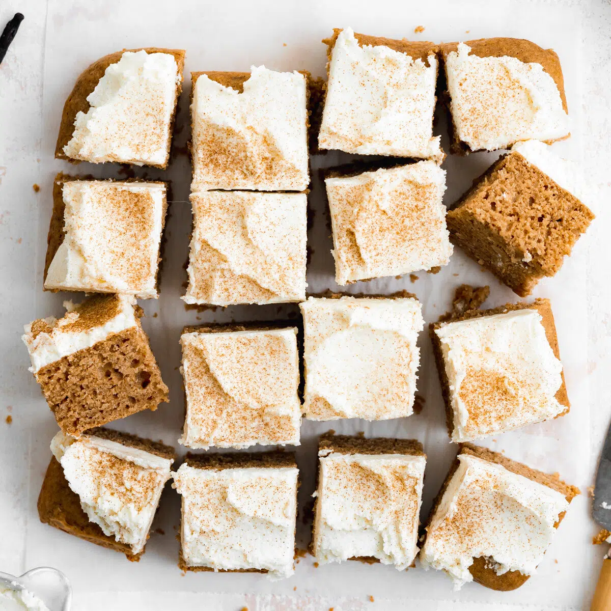 sliced vegan sheet cake with chai spices and cream cheese frosting.