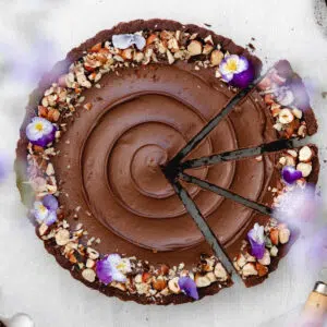 flat lay of nutella tart with edible purple and lilac pansies.