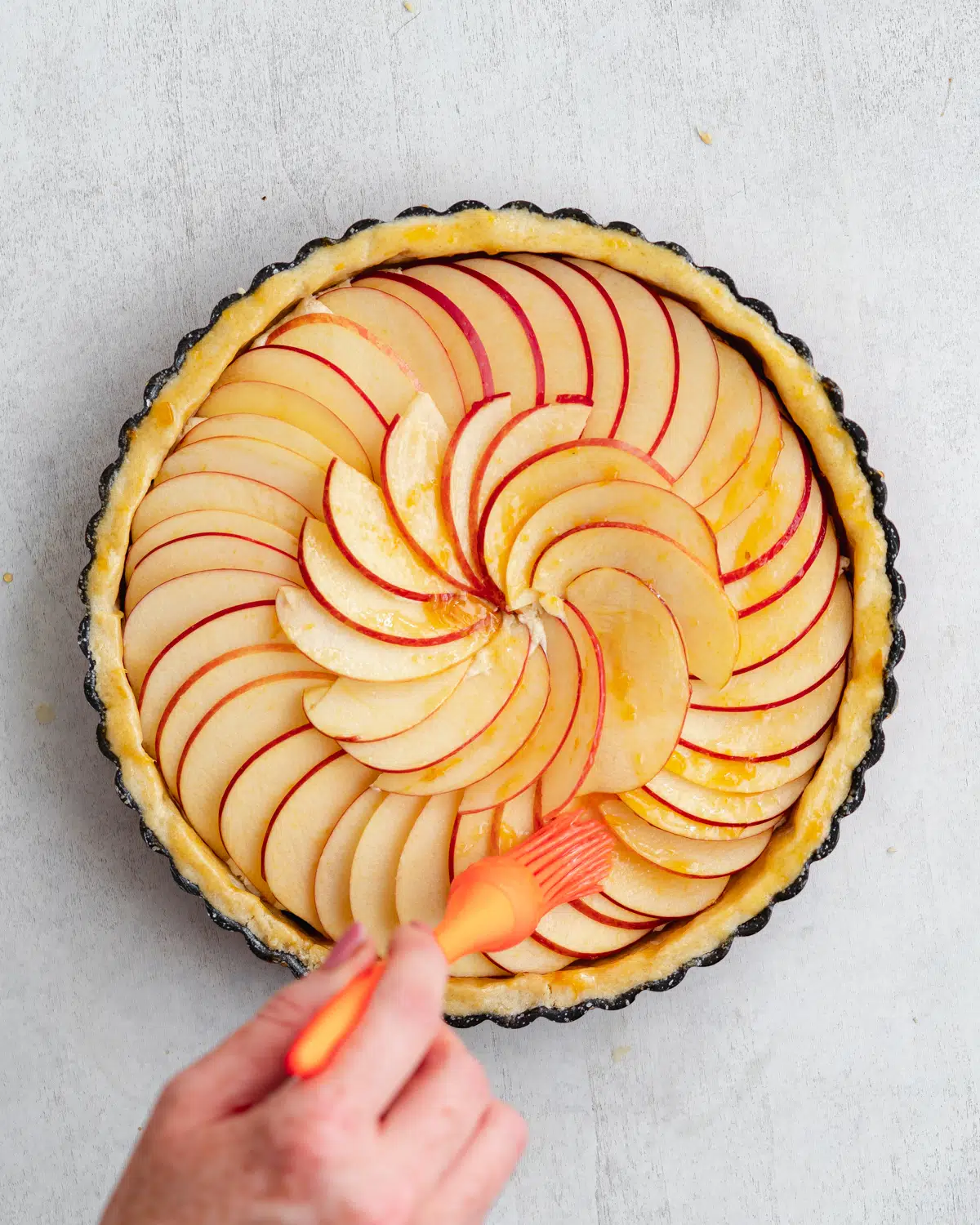 brushing apple tart with apricot glaze.