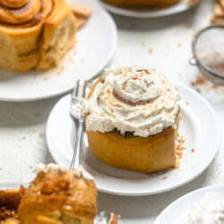 iced vegan cinnamon rolls with sweet potato filling on a plate.