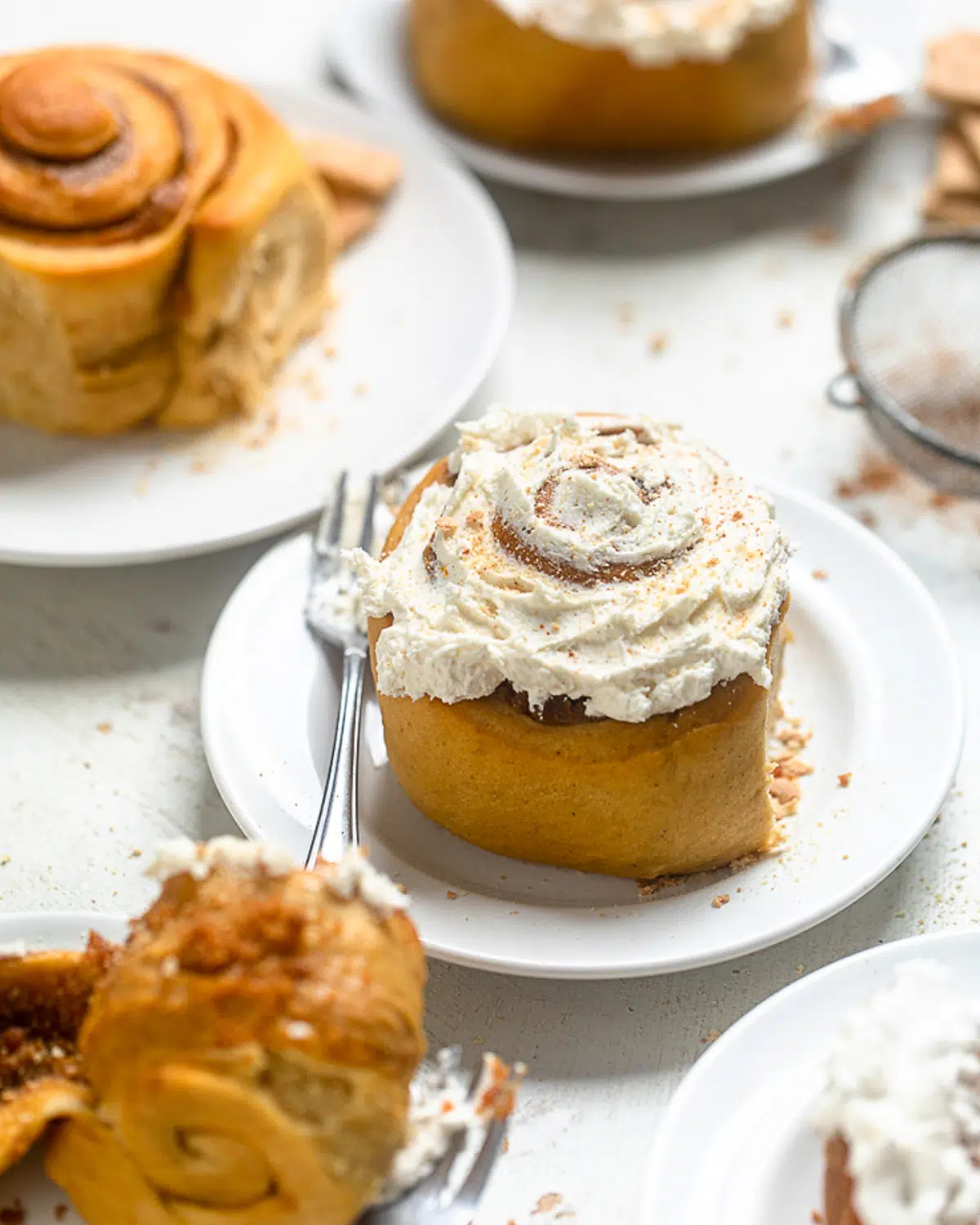 iced vegan cinnamon rolls with sweet potato filling on a plate.