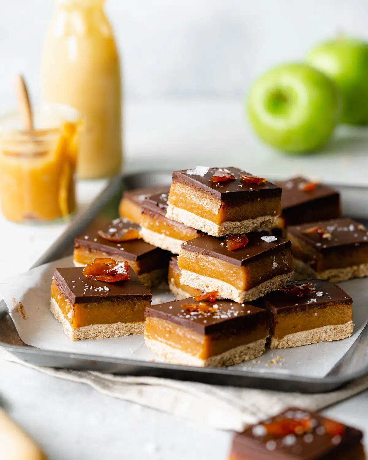 stack of vegan toffee millionaire shortbread bars with apples.