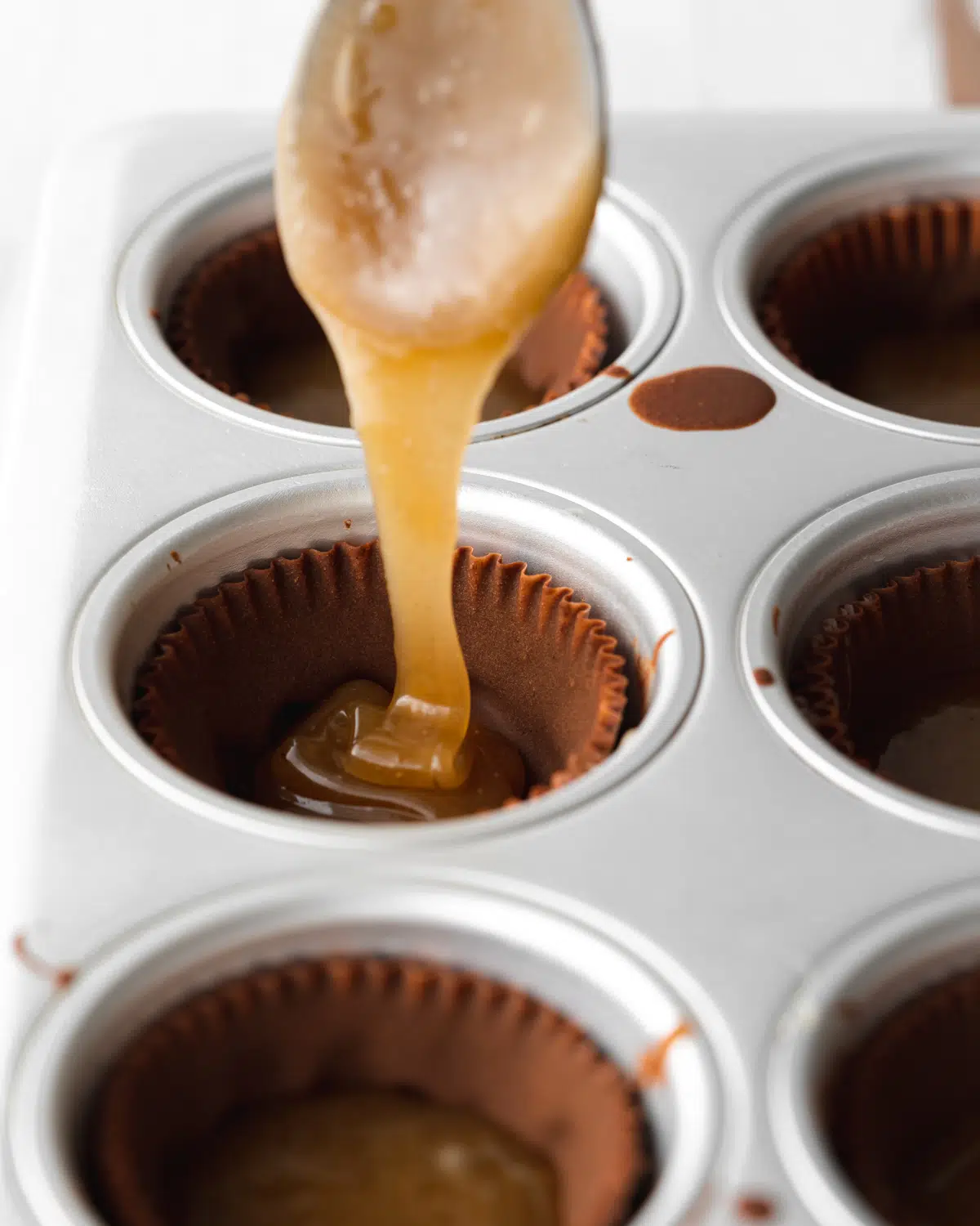 filling chocolate cups with caramel sauce.