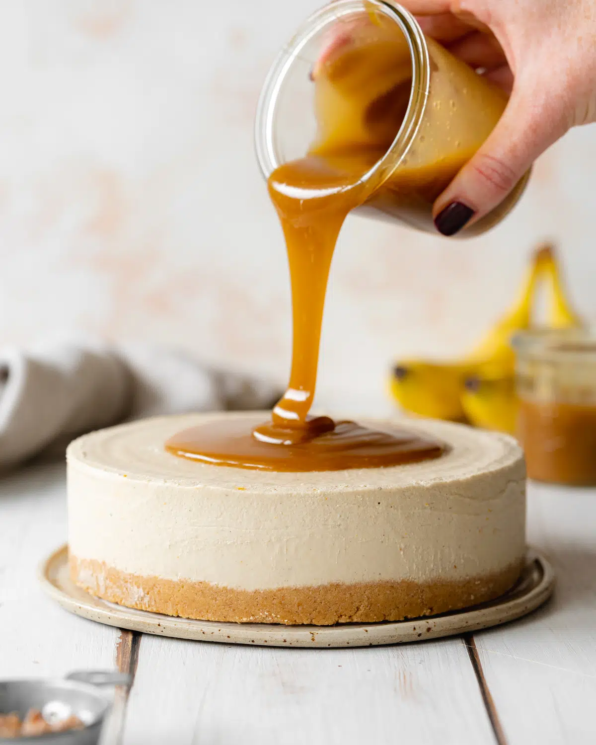 dairy free banana cheesecake with caramel sauce poured over it.