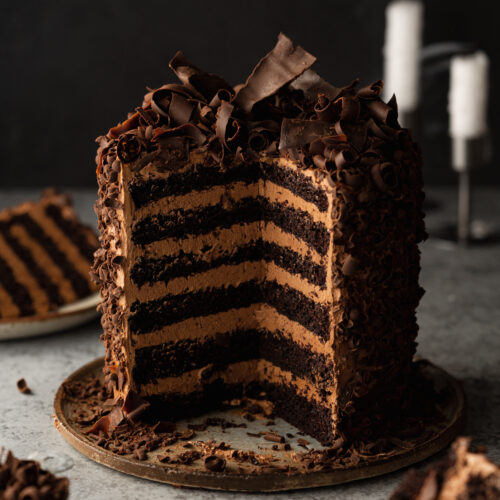 layered vegan chocolate cake with chocolate buttercream and chocolate shavings.