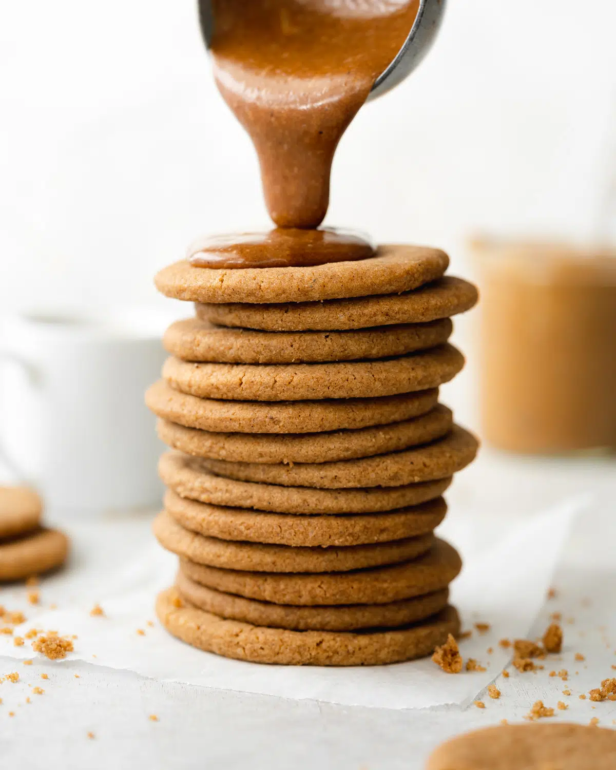 stack of vegan speculoos cookies with cookie butter pouring over them.