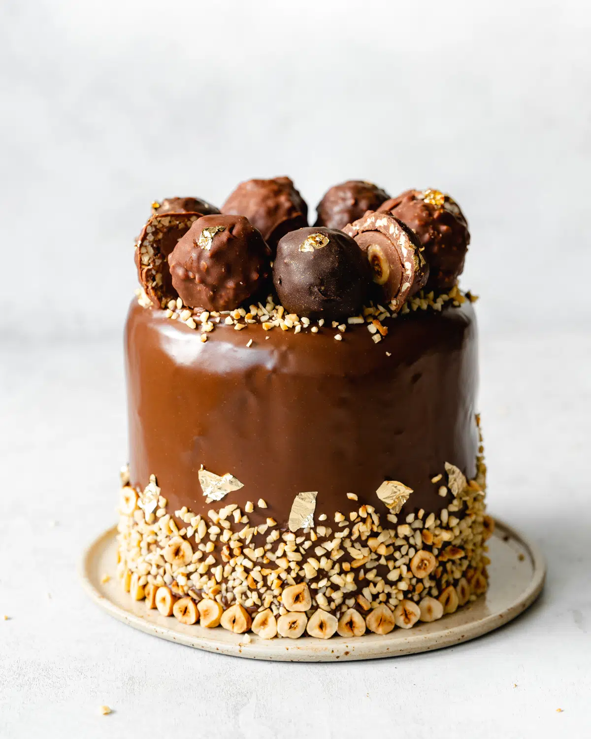 layered chocolate hazelnut cake with ferrero rocher on top.