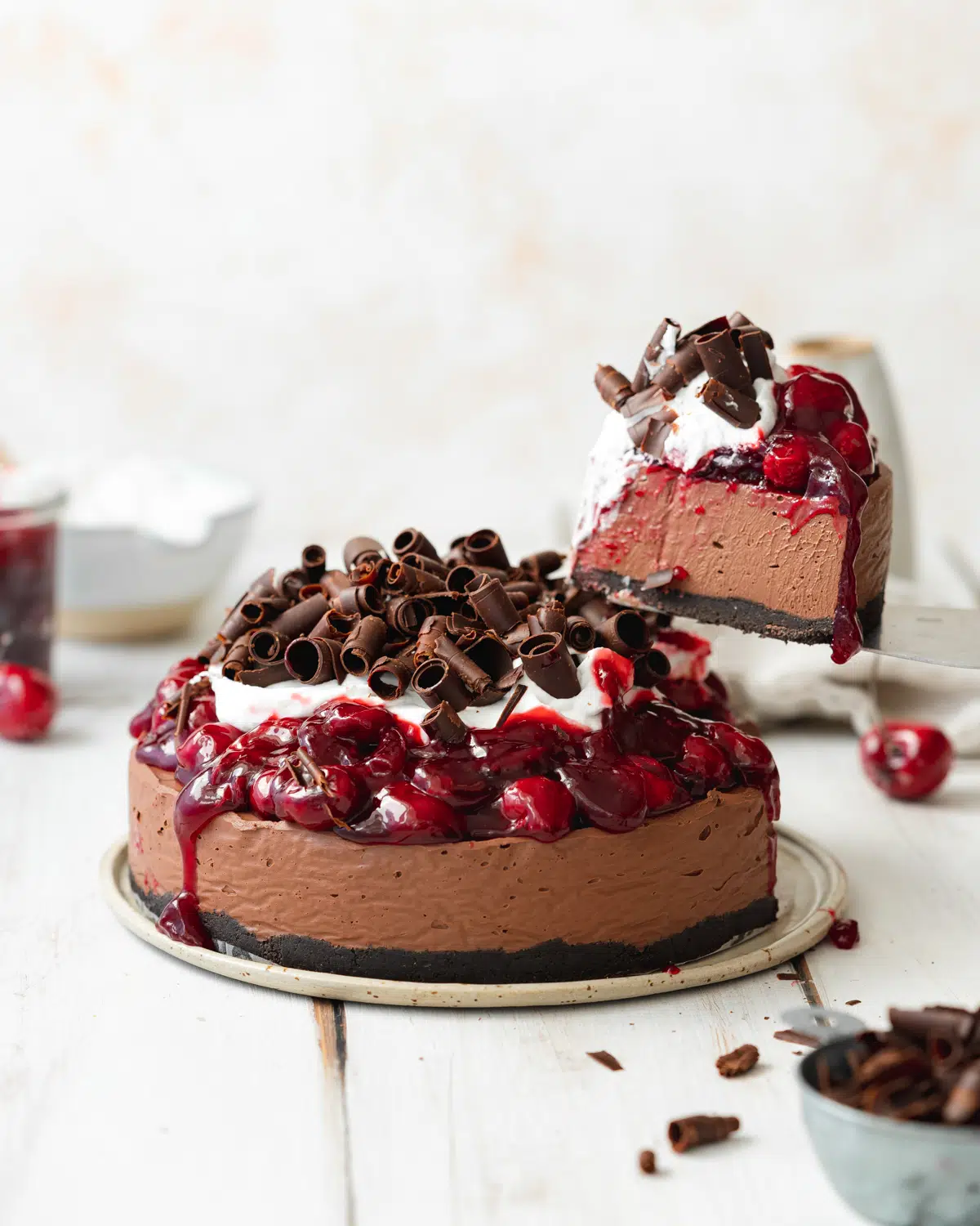 cherry chocolate cheesecake with slice being taken out of it.