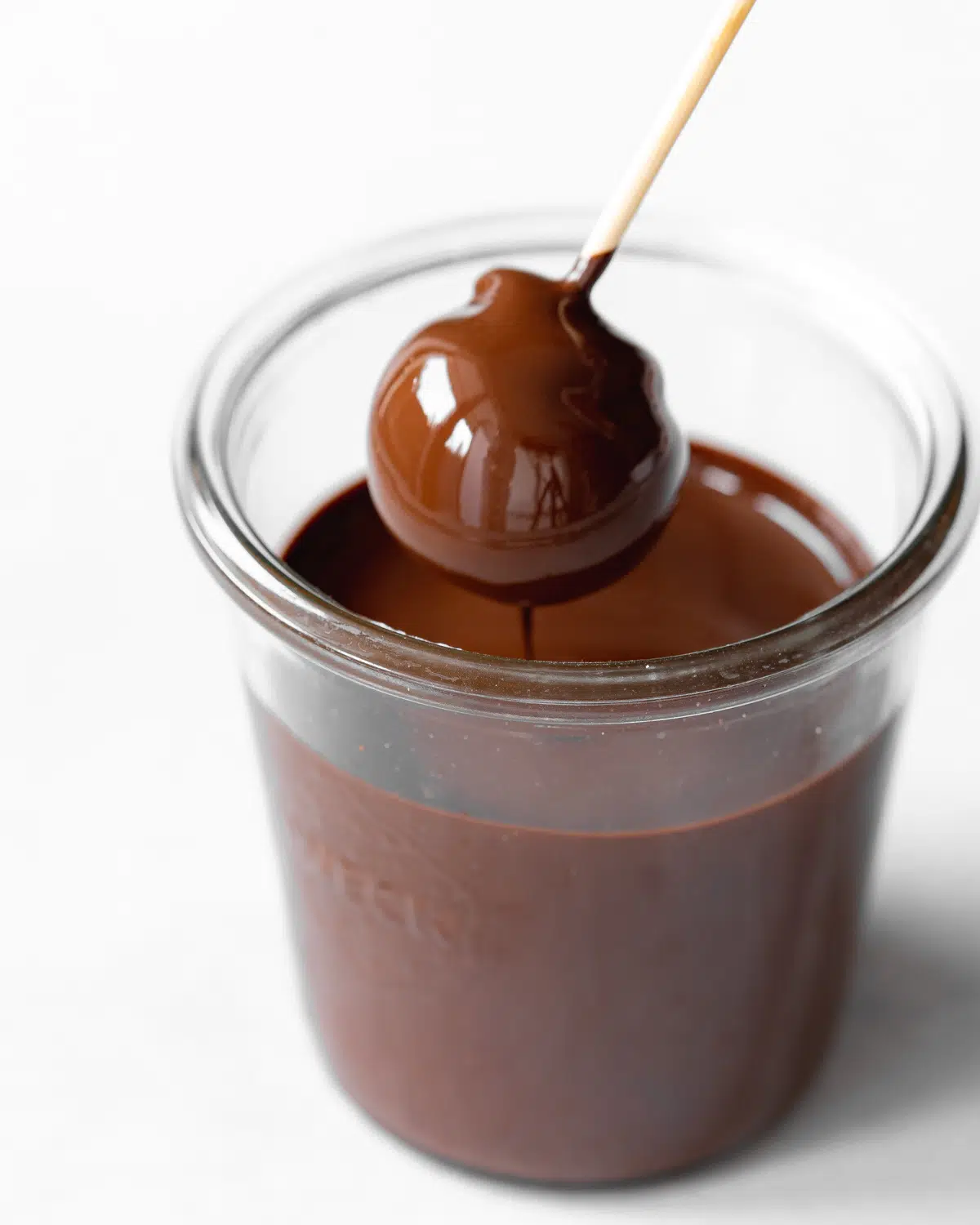 dipping truffle into chocolate sauce.