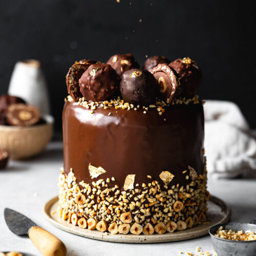 chocolate glazed cake with hazelnuts and ferrero rocher on top.