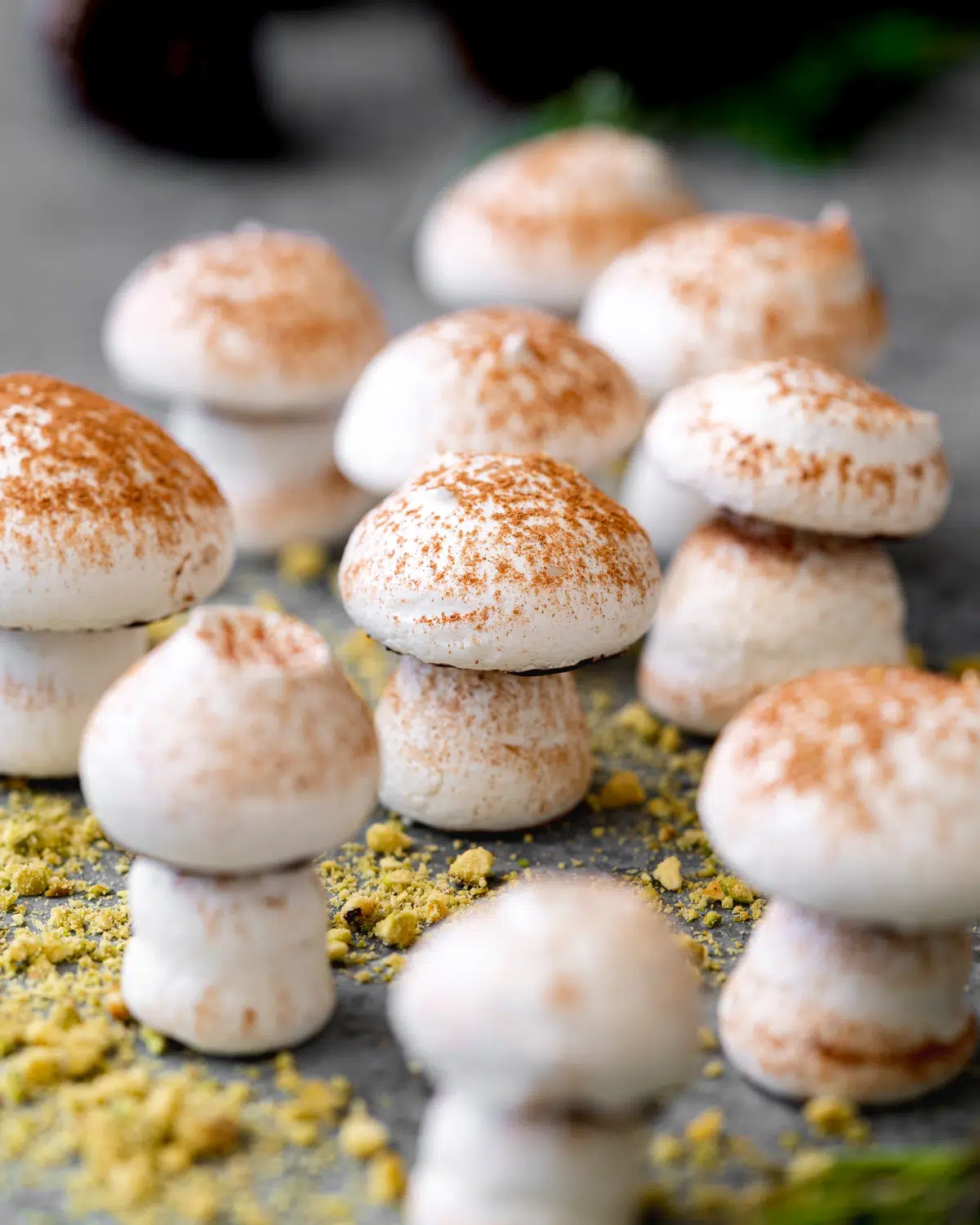 aquafaba meringue mushrooms on green pistachio crumble.