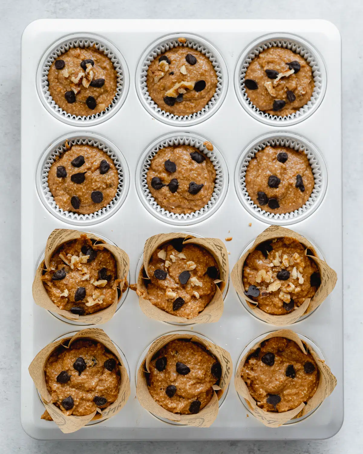 chocolate chip banana muffins in a lined muffin tray.