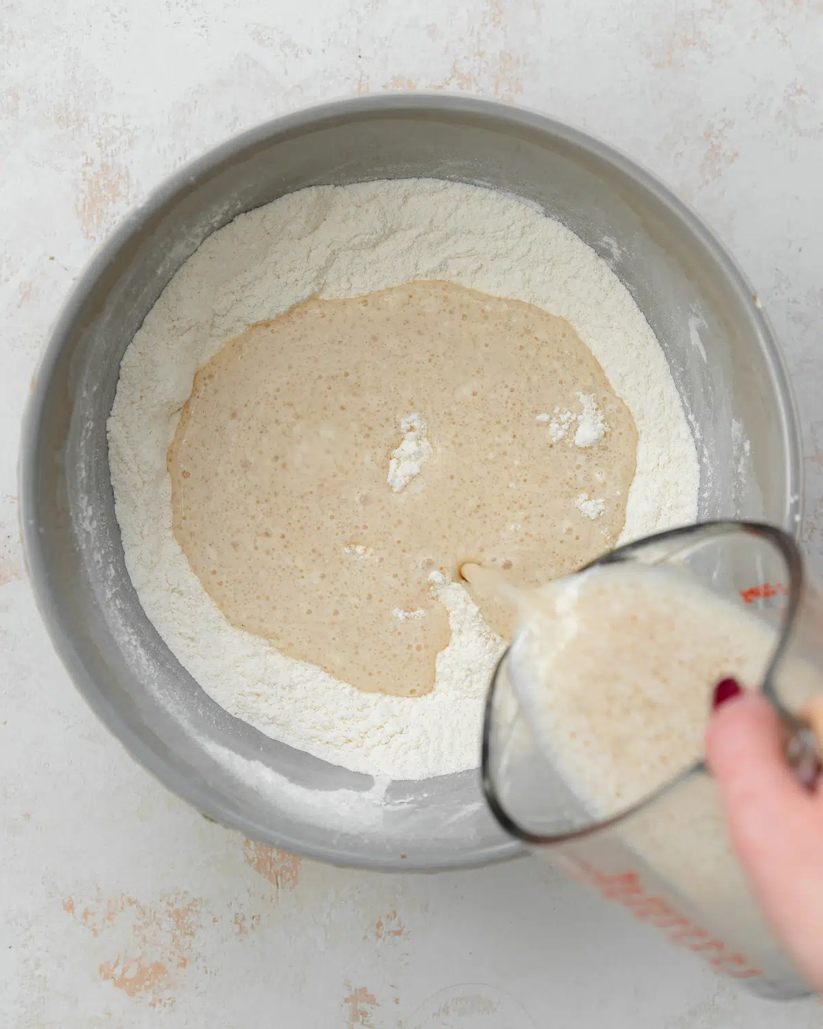 pouring milk into dry ingredients to make cupcakes.