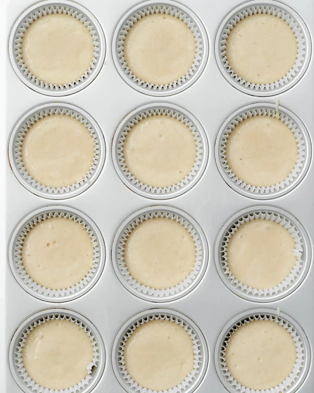 cupcake batter in a lined tray.