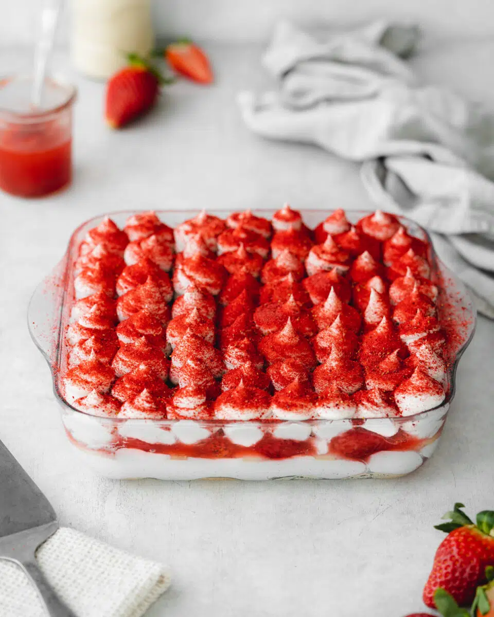 vegan layered tiramisu with strawberries and strawberry powder on top.