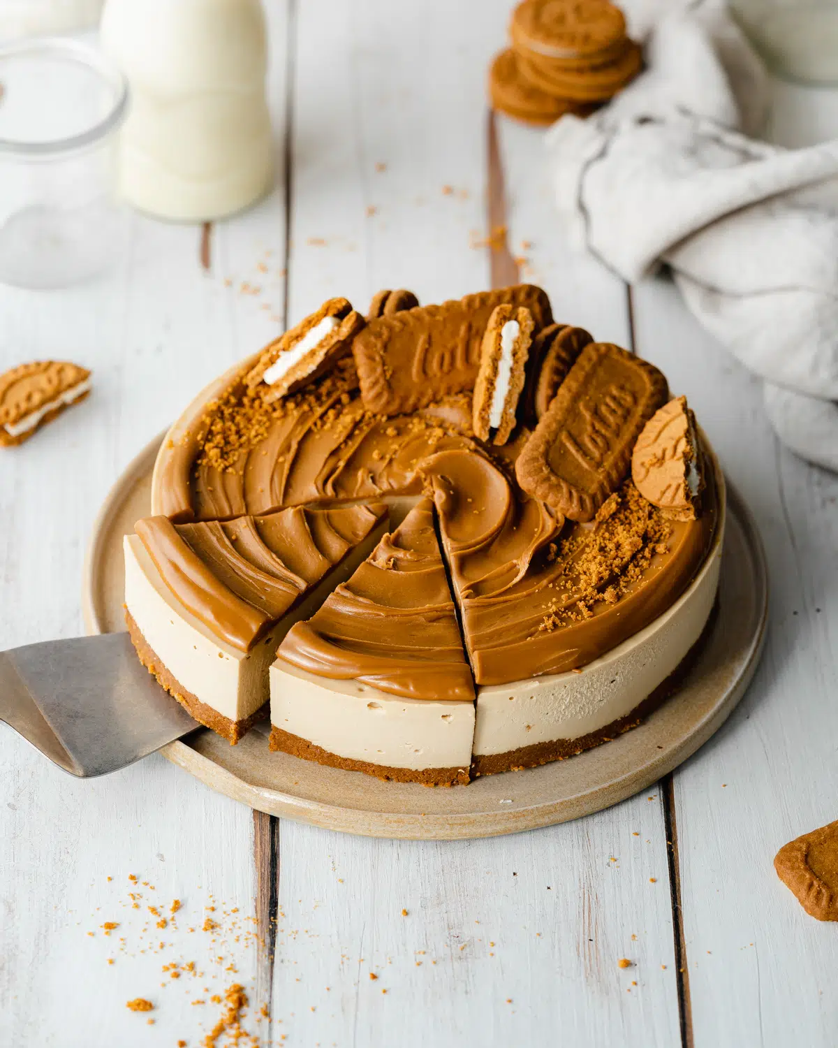 vegan biscoff cheesecake on a white wooden surface.