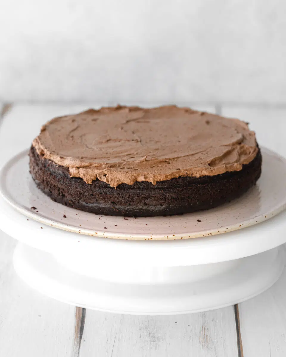 chocolate cake with chocolate buttercream on a lazy susan.