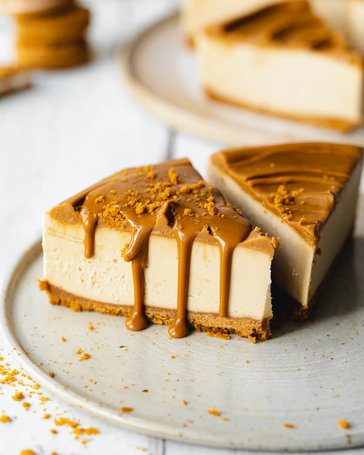 slice of lotus biscoff cheesecake with melted biscoff spread dripping down the sides of it.