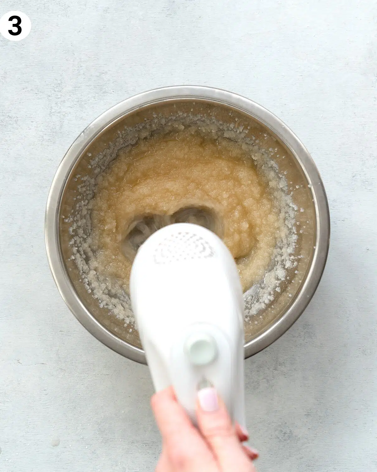 whisking sugar and oil with an electric mixer.