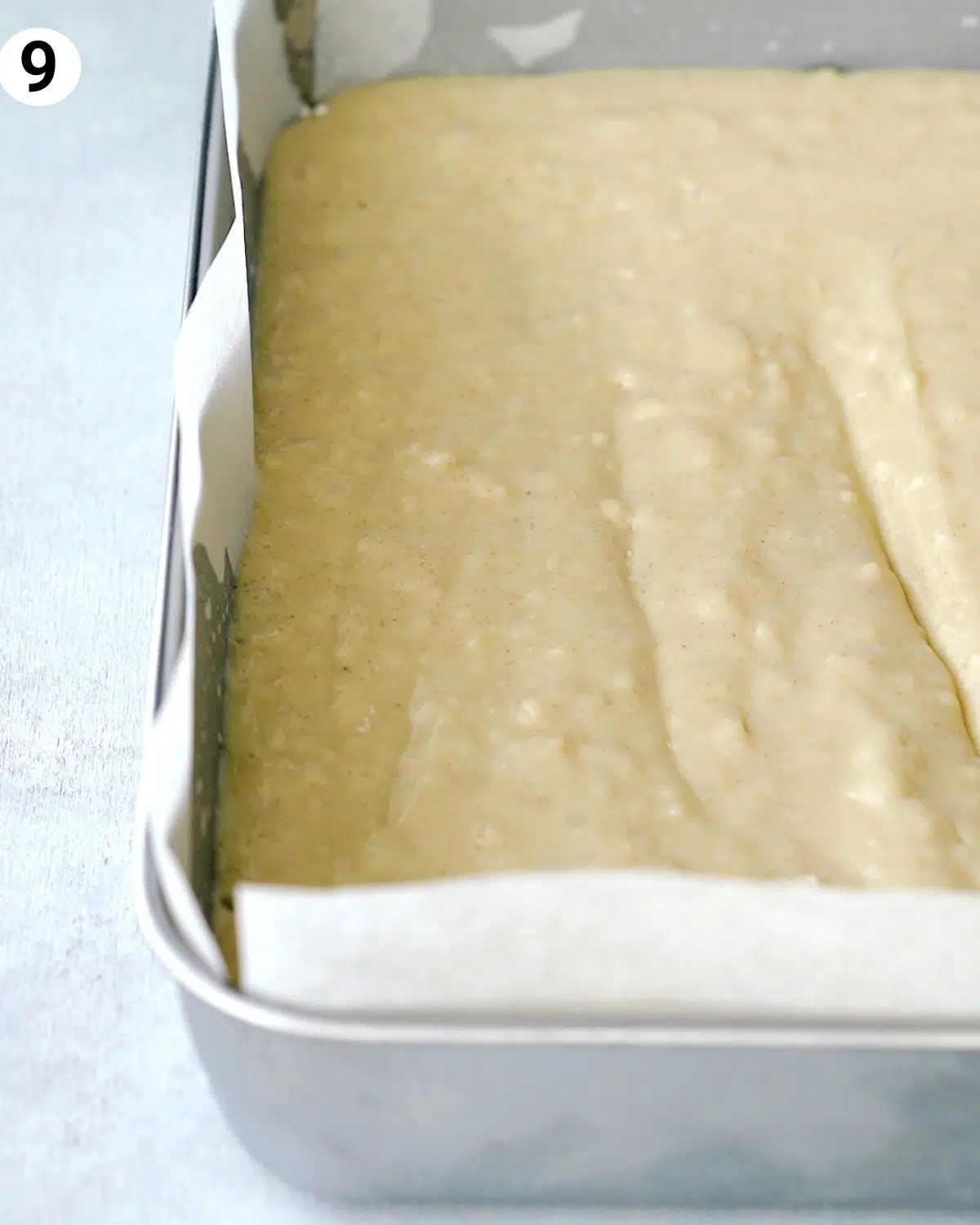 side view of tres leches cake in a metal square baking tin.