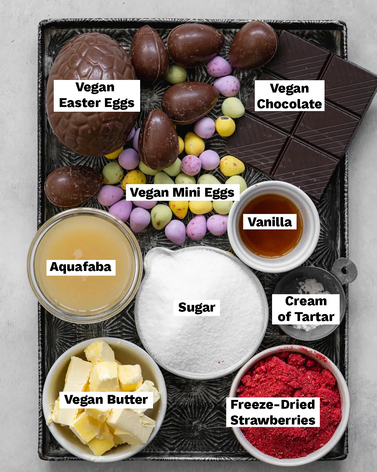 vegan easter cake toppings laid out on a metal tray.