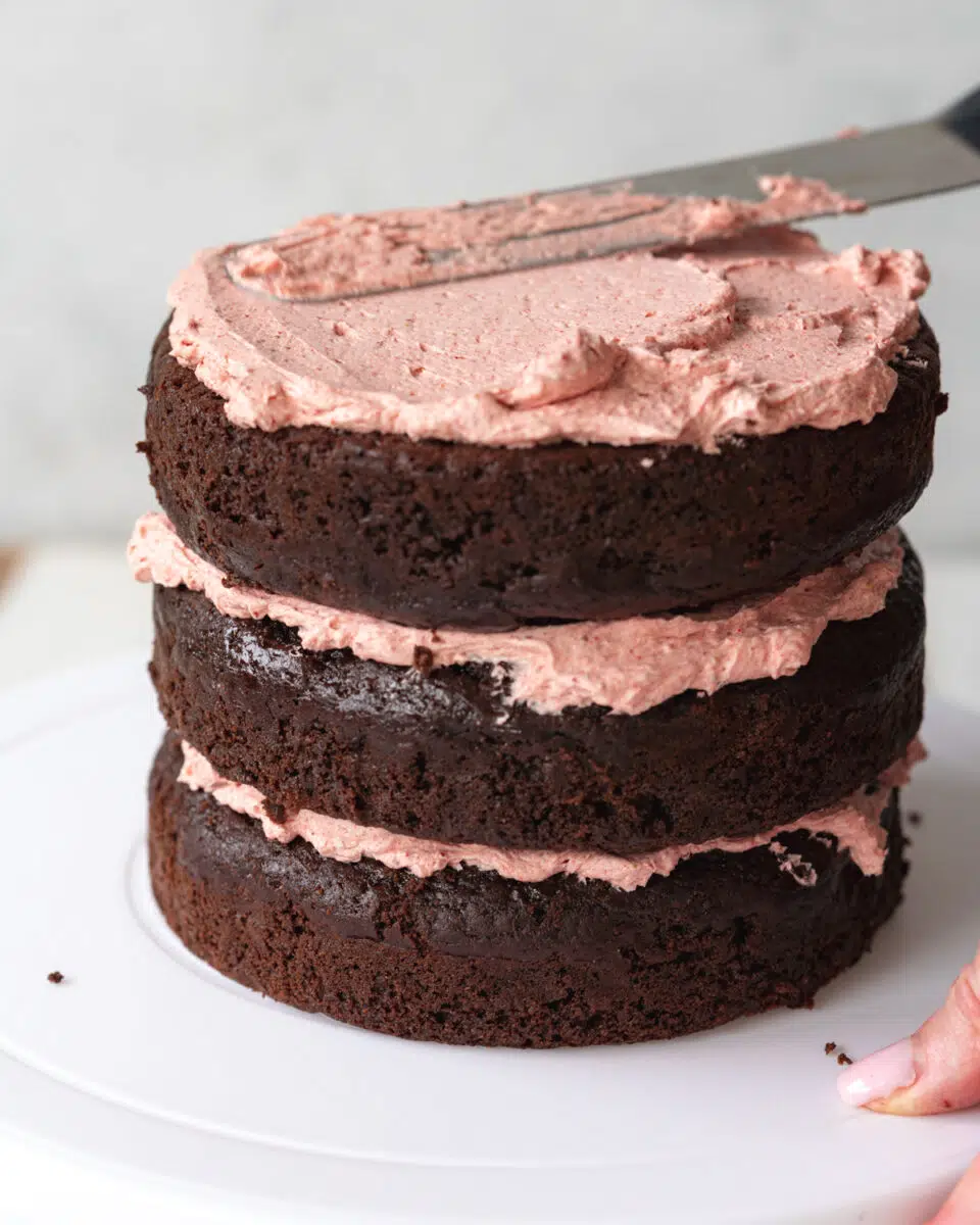 three layer chocolate cake with strawberry frosting.
