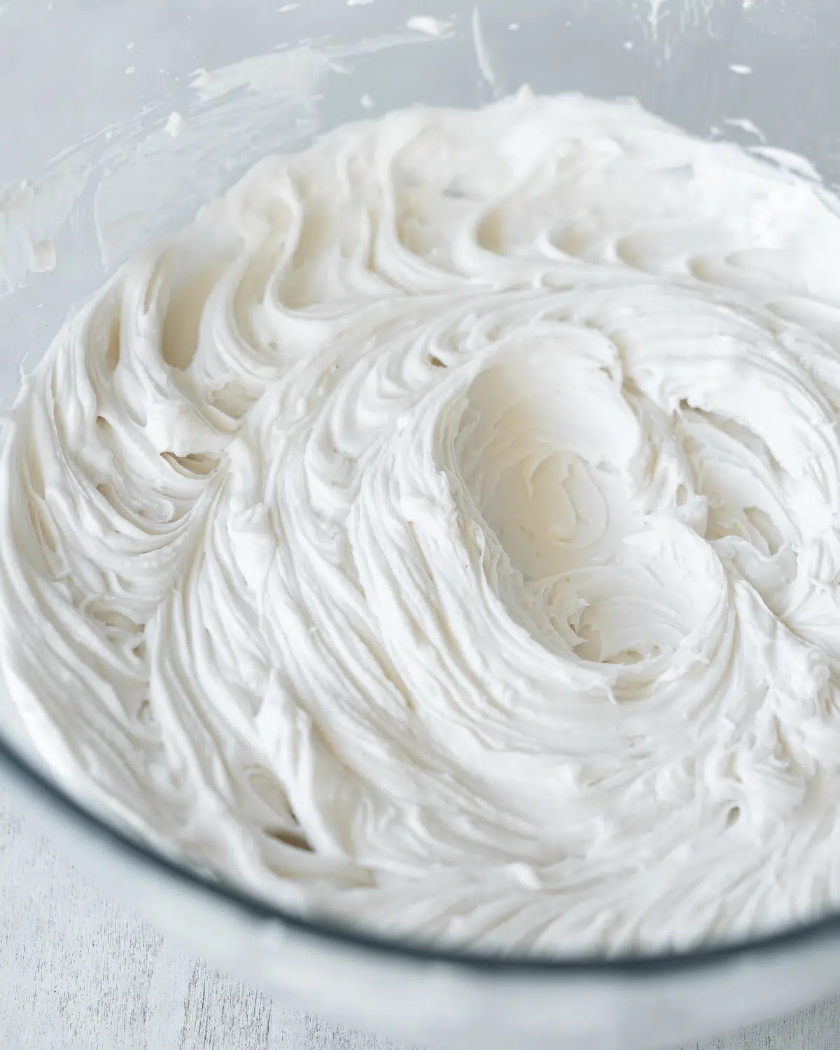 close up of whipped coconut cream in a clear bowl.