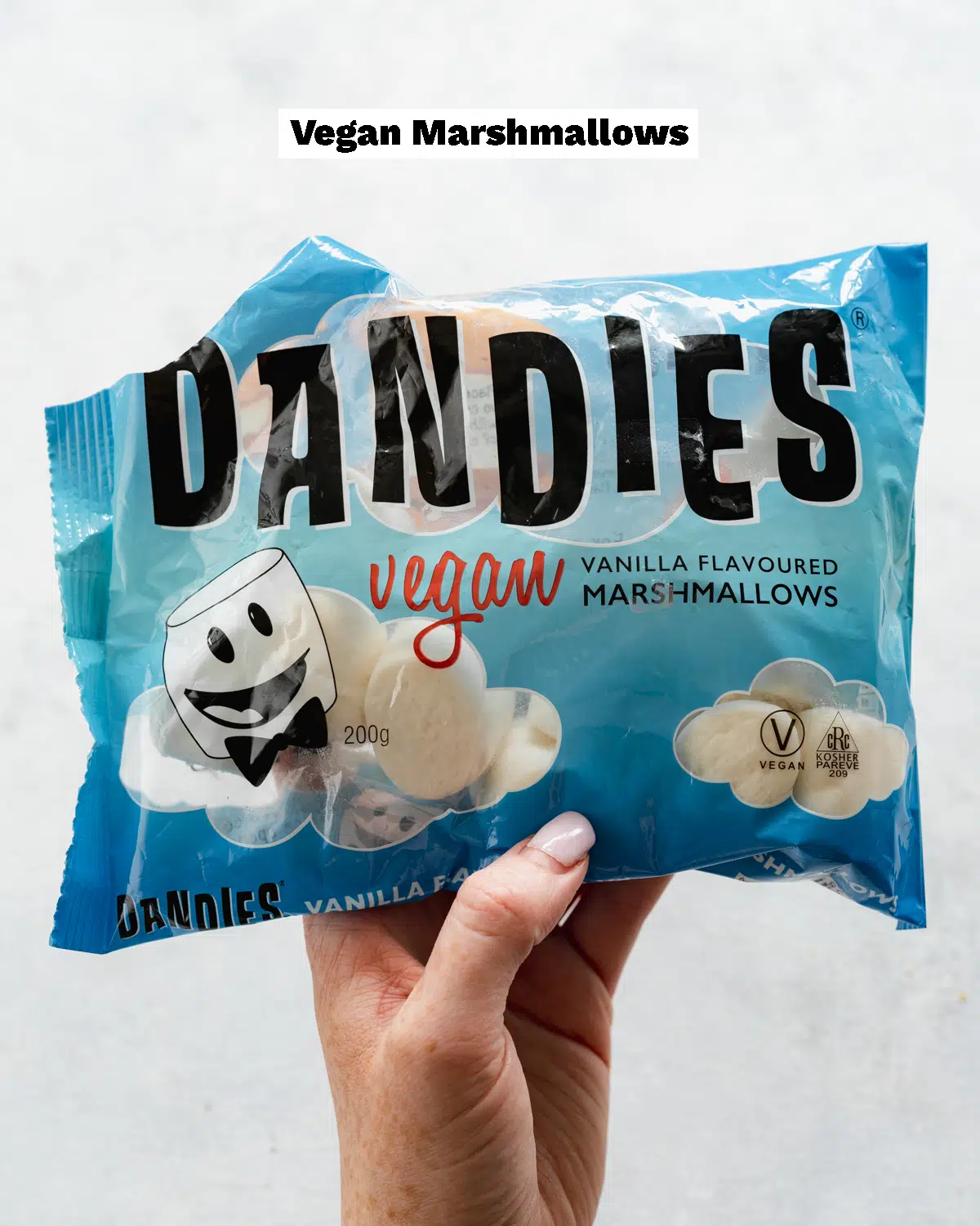 hand holding up a bag of vegan marshmallows.