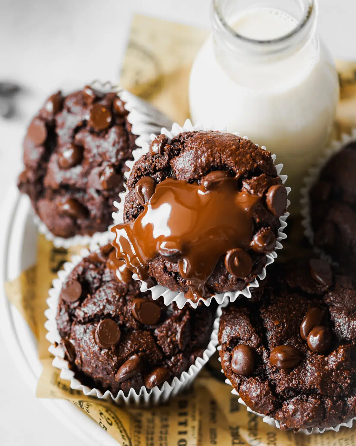 chocolate muffins with melted chocolate on top and a jug of milk.