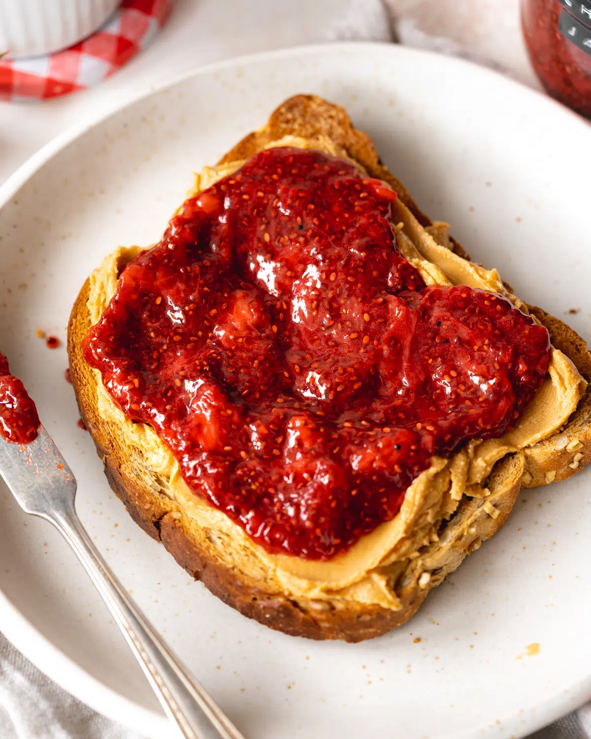 slice of toast with peanut butter and strawberry jam.