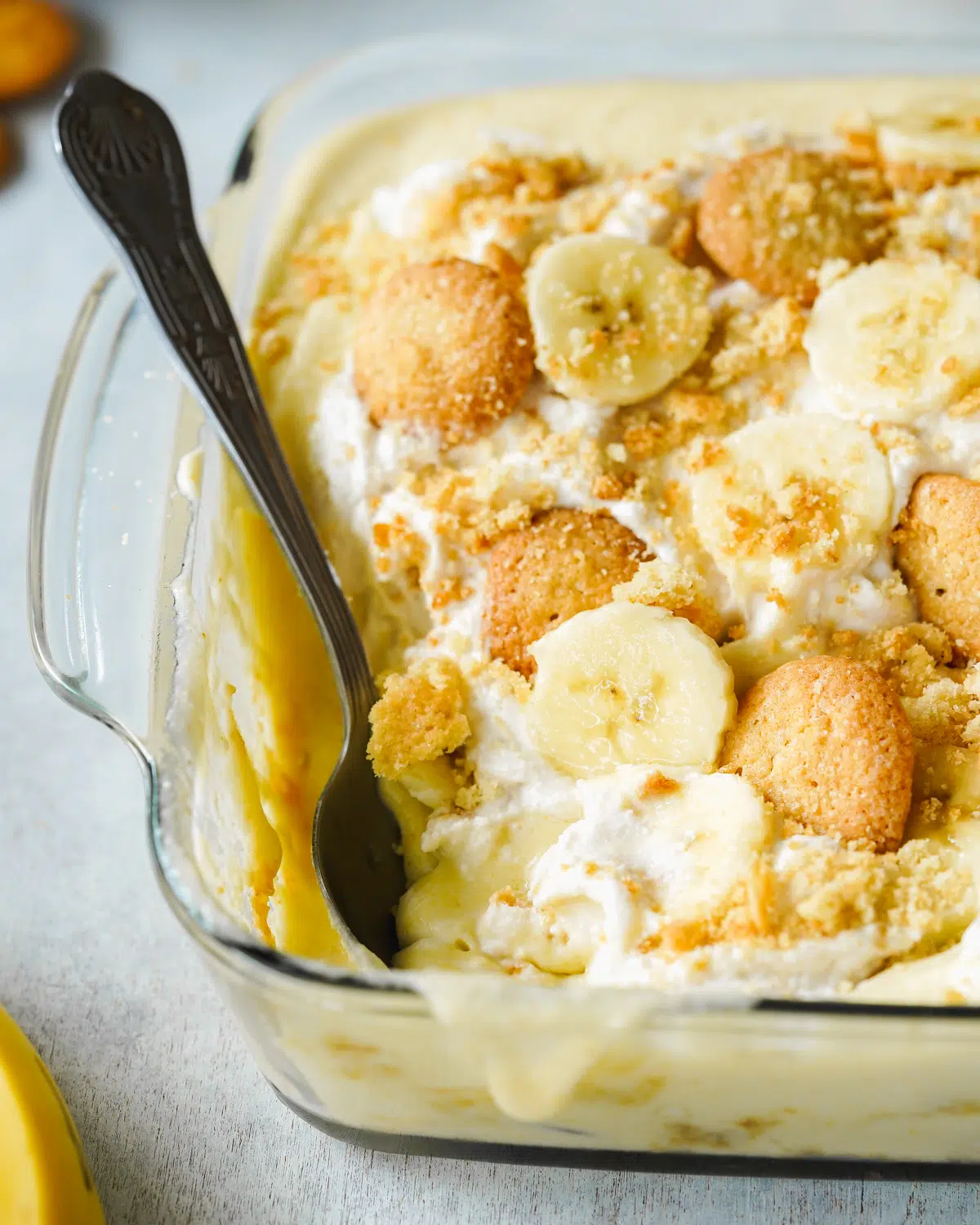 banana pudding with fresh bananas and oat cream in a clear baking dish.