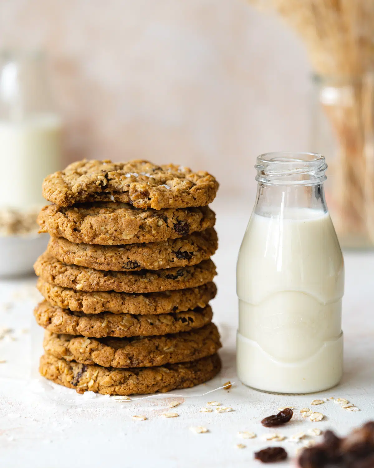 stack of oatmeal raisin cookies next ti a jug of oat milk.