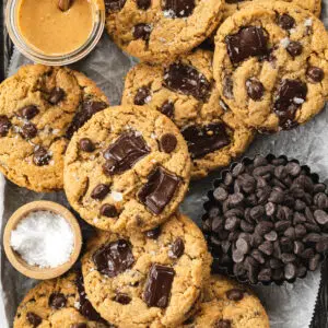 peanut butter chocolate chip cookies on a tray with peanut butter, sea salt, and chocolate chips.