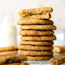 a stack of vegan snickerdoodle cookies with a small jug of milk in the background.