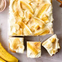 banana cake with vanilla frosting and banana slices on top.