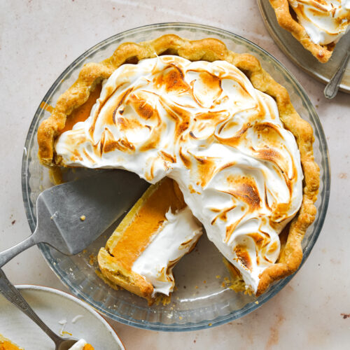 sweet potato pie in a glass dish with toasted meringue topping.