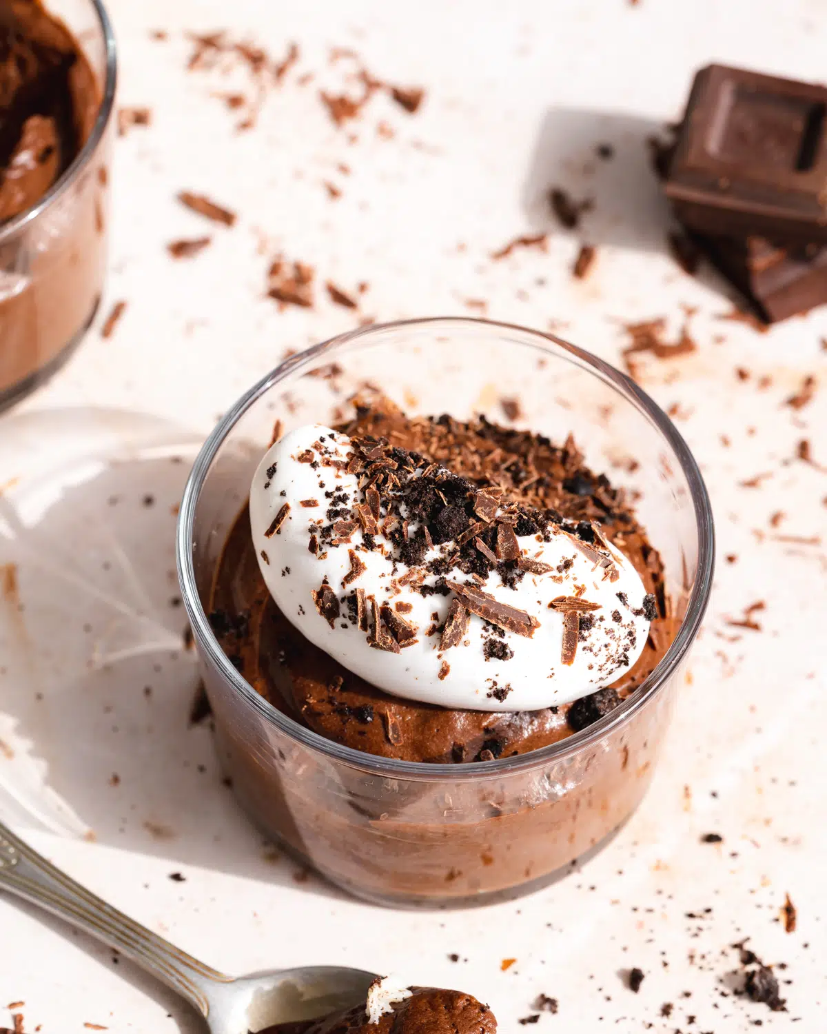 chocolate mousse in a small jar with whipped aquafaba and chocolate shavings on top.