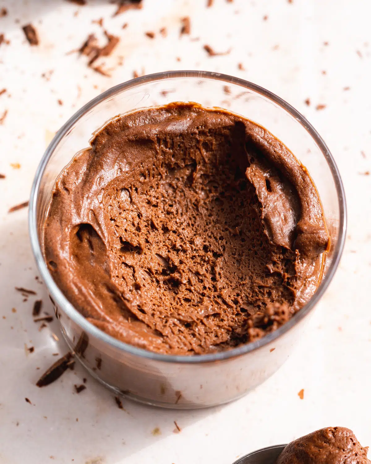 chocolate mousse in a small glass serving jar with a spoonful taken from it.