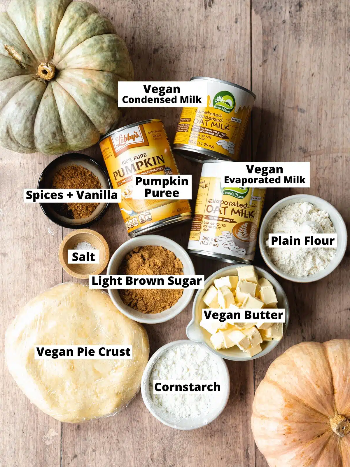 ingredients for vegan pumpkin pie measured out on a wooden surface.