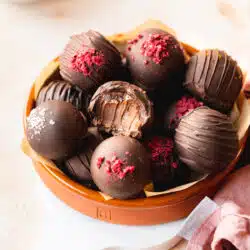 chocolate truffles with raspberry powder in a terracotta bowl.