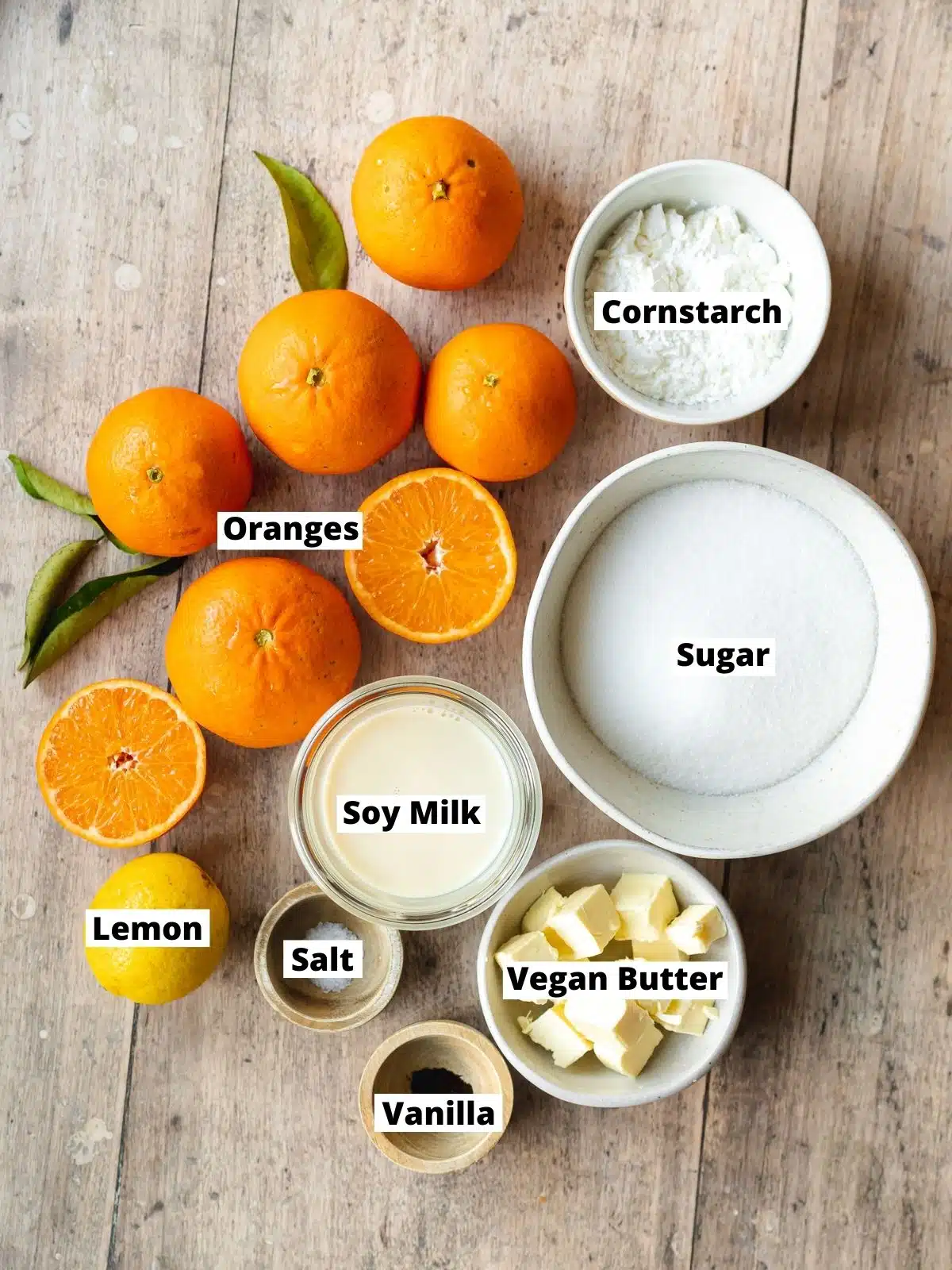 ingredients for orange curd measured out in bowls on a wooden table.